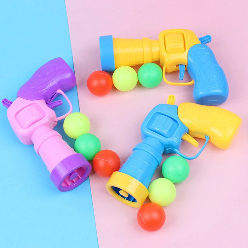 Eine Sammlung farbenfroher Plastik-Katzen-Haarkugel-Waffen in Gelb, Blau, Pink und Grün.