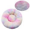 A plush round pet bed with a pink and blue striped cover and a separate fluffy pink cover.