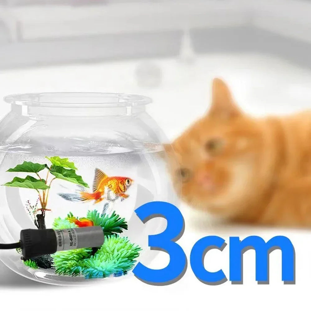 Un pequeño acuario de vidrio con un pez dorado y plantas acuáticas, demostrando el tamaño de 3 cm de una resistencia USB ajus