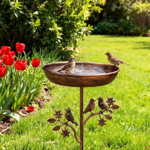 Robuste GartenVogelbad mit Metallständer auf grüner Rasen mit roten Tulpen und Blättern.