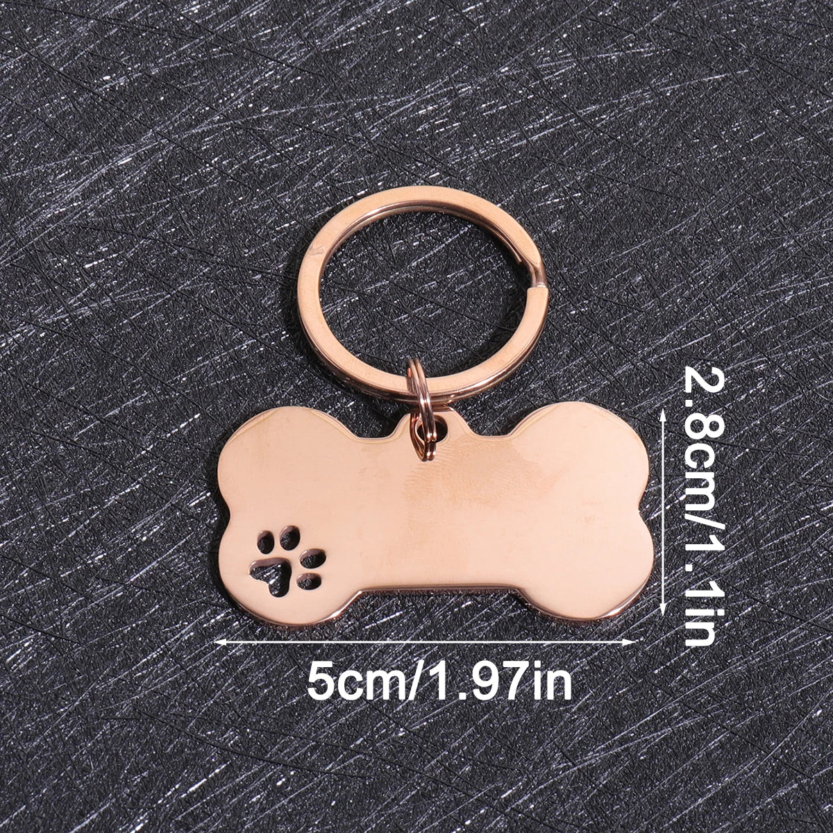 A gold-colored bone-shaped dog ID tag with a circular loop, shown against a dark gray background.