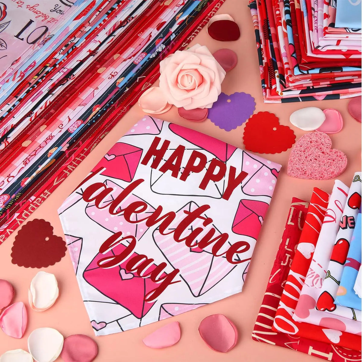 A collection of pink and red Valentine's Day themed items including heart-shaped fabric pieces and dog bandanas.
