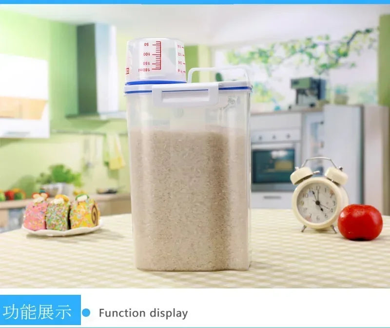 A clear airtight pet food storage container with a measuring cup is displayed on a table.