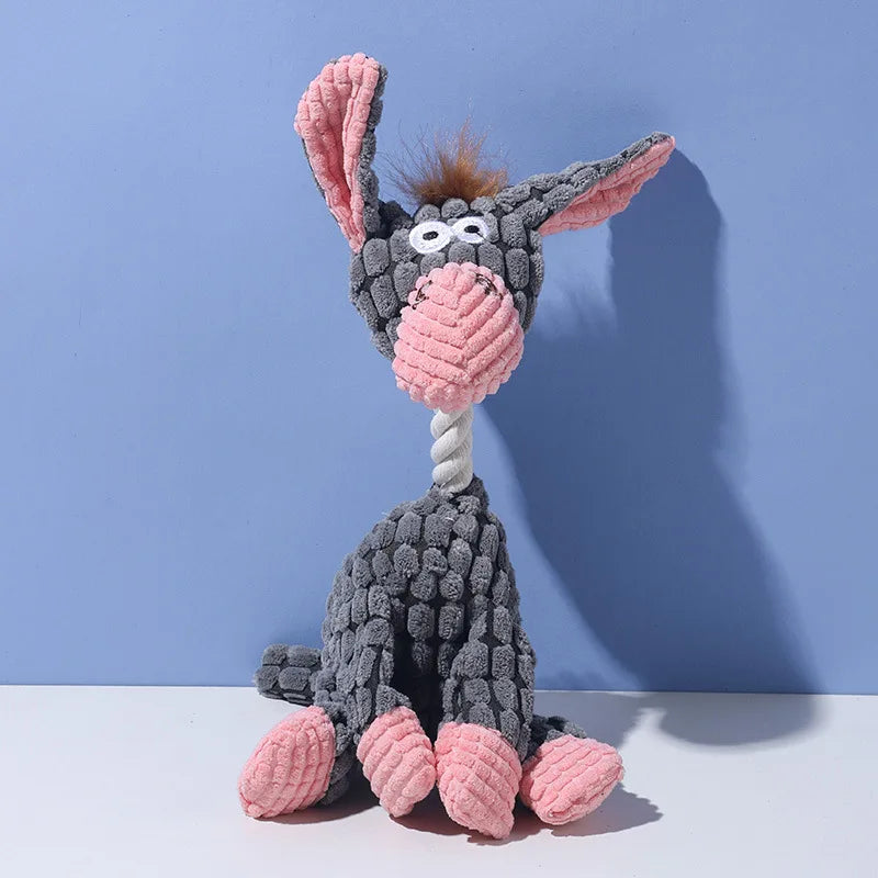 A gray plush toy shaped like a donkey with pink ears and a pink nose, featuring a teeth cleaning texture.