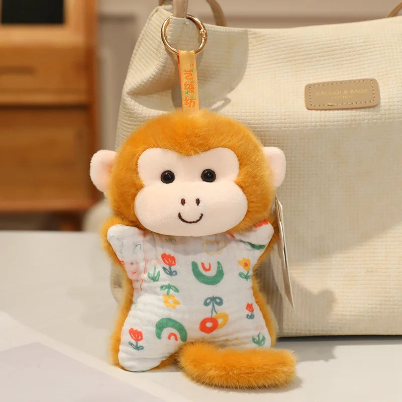 A fluffy orange monkey plush toy with large eyes and a cute expression hanging from a light beige bag.