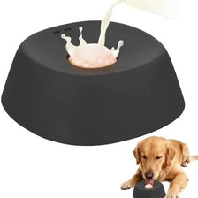 A dark gray anti-choking slow feeder dog bowl with a white food being fed into the opening.
