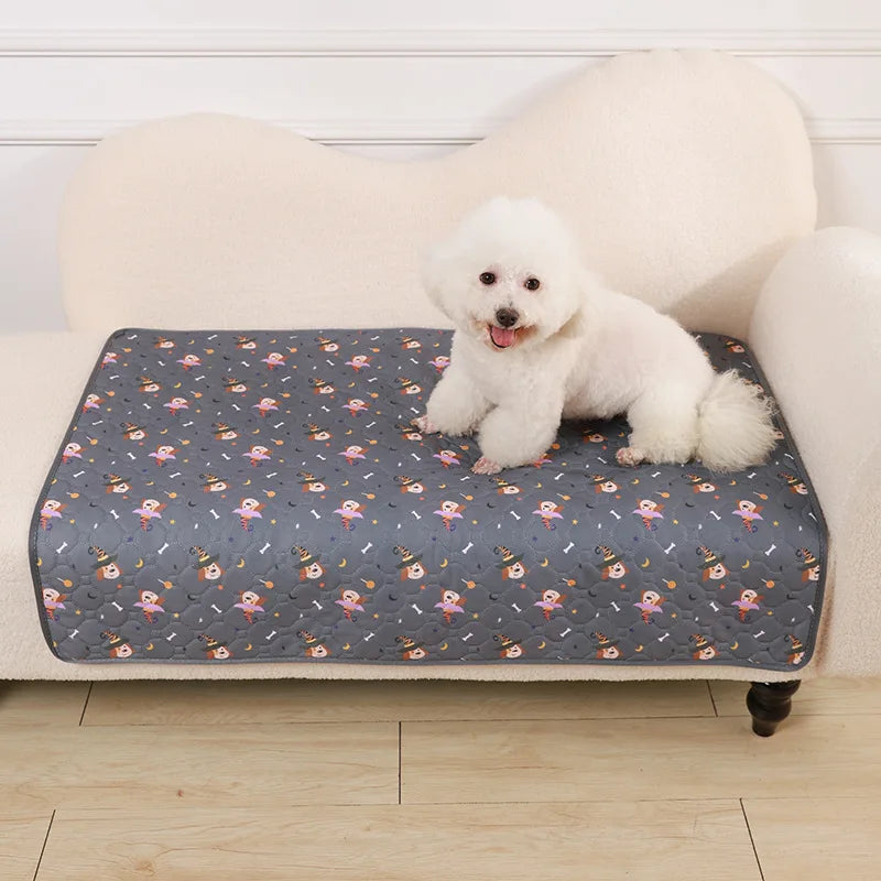 A fluffy white puppy is lying on a gray pet pad in front of a cream-colored sofa.
