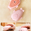 Pink electric pet grooming brush used for massaging, showering, and brushing pets.