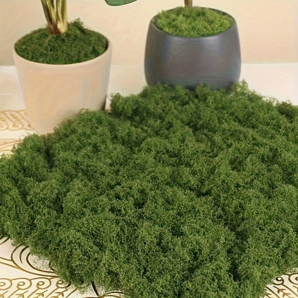 A large pile of vibrant green preserved moss is displayed next to a potted plant.