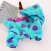 Un costume de chien en polaire turquoise vif à pois violets, présenté à côté d'un rouleau de fil gris.