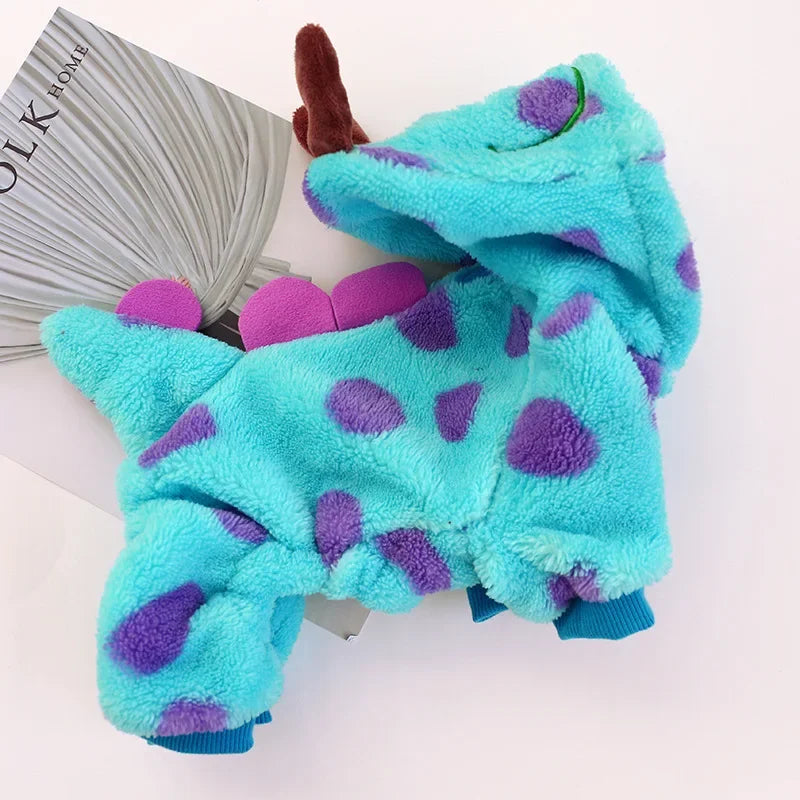 Un costume de chien en polaire turquoise vif à pois violets, présenté à côté d'un rouleau de fil gris.