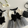 Vestido de malla blanco y negro para perros con detalle de lazo y accesorios florales.