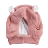A pink knit beanie with white ear muffs for dogs