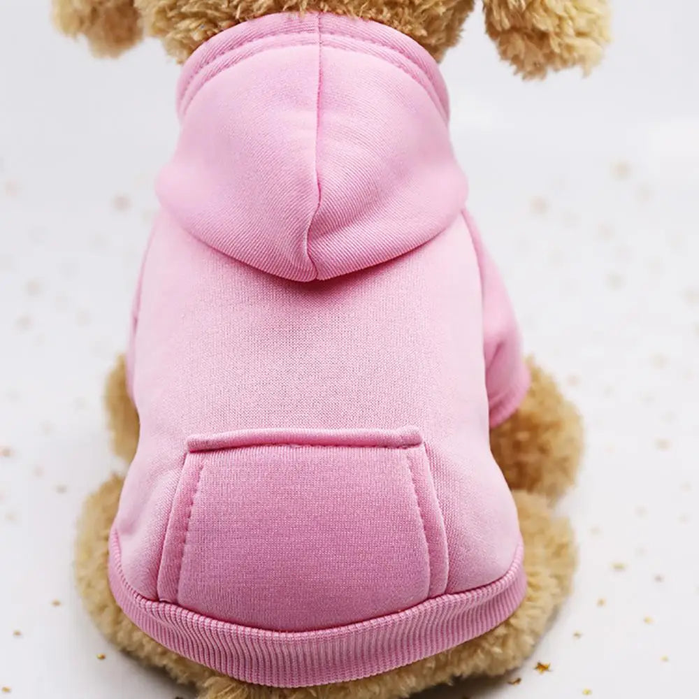 A pink cozy hooded sweatshirt for a dog is shown against a white background.