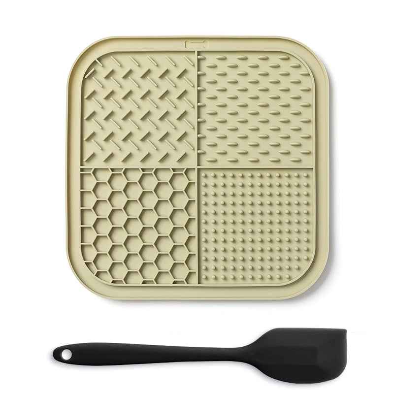 A beige silicone lick mat for pets with suction cups and a black silicone spoon.