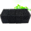 Two black aquarium bio sponge filter media blocks with green plant leaves in the background