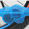 A blue bike chain cleaner device with a brush system is shown mounted on a bicycle tire.