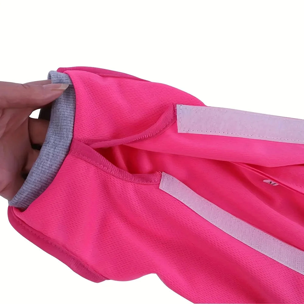 A hand is holding a bright pink, textured cat recovery suit fabric.