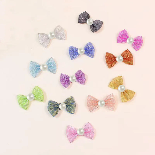 A collection of various colored and glittery bow knots for pet grooming.