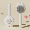 A white pet deshedding brush for cats and dogs with a self-cleaning design shown in a studio setting.