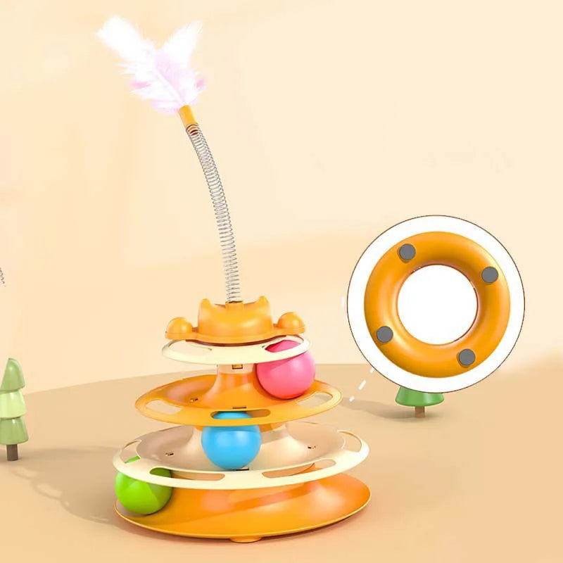 An orange interactive cat turntable toy with a feather wand and rolling ball on a light background.