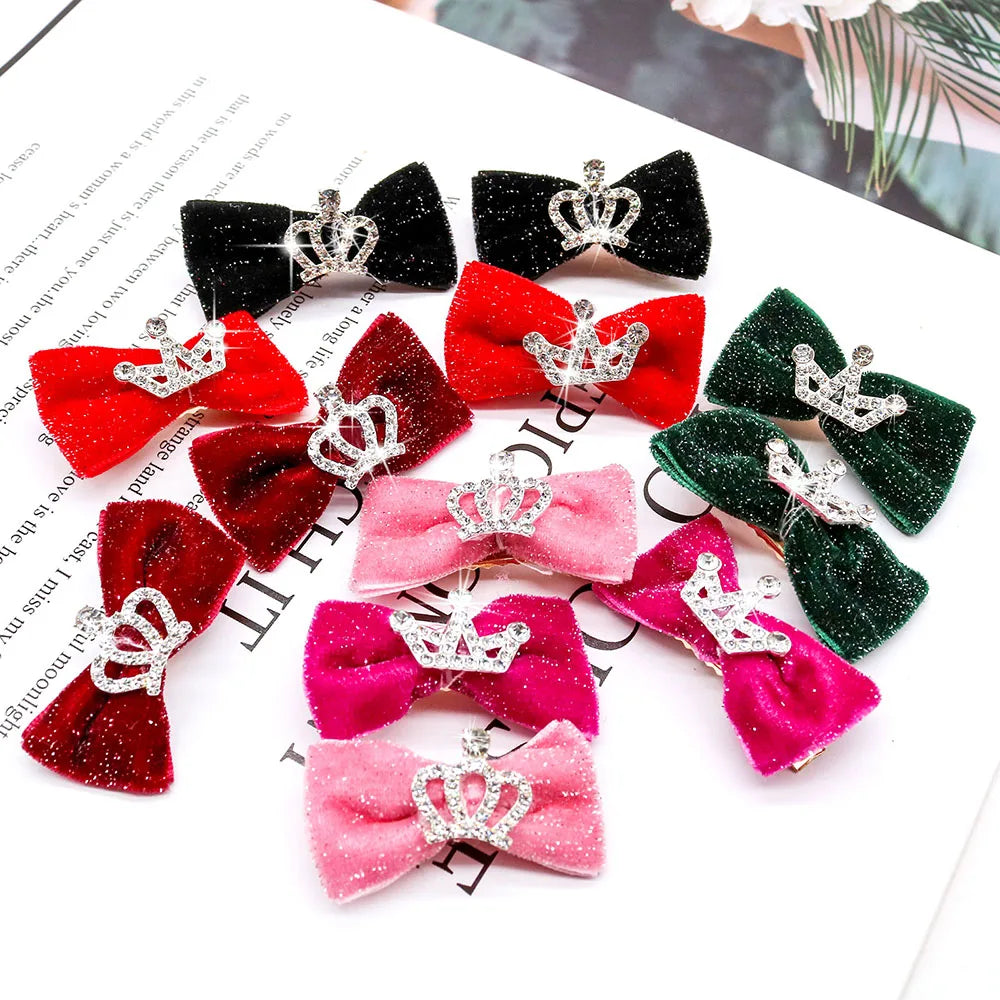 A collection of glitter dog hair clips in various colors like black, red, pink, and green with crown designs.