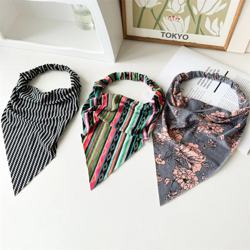 Tres pañuelos de tela con diferentes patrones, incluyendo rayas blancas y negras, rayas multicolores y flora gris