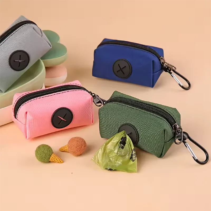 Une collection de pochettes en tissu colorées et un distributeur de sacs pour chiens sur un porte-clés vert, sur un fond clai