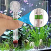 Eine Hand hält ein vertikales schwimmendes Aquariumthermometer mit roter Flüssigkeit und misst die Temperatur auf einer Waage
