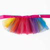 A colorful tulle tutu dress for a small dog, featuring multiple shades of pink, orange, purple, and blue.