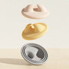Three silicone pet can openers and feeding spoons in pink, yellow, and gray stacked vertically.