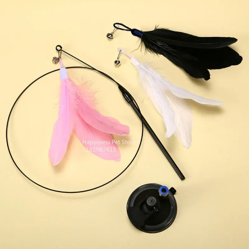 A black suction cup cat teaser wand with replaceable feather toys, including pink and white feathers.