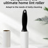 A black lint roller with a white cylindrical holder is shown on a white surface.