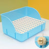 Una caja de arena rejillada azul claro y desmontable para pequeños mamíferos, mostrada sobre una superficie blanca.