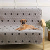A light gray quilted dog urine pad with a black paw print pattern is shown on a wooden stand.