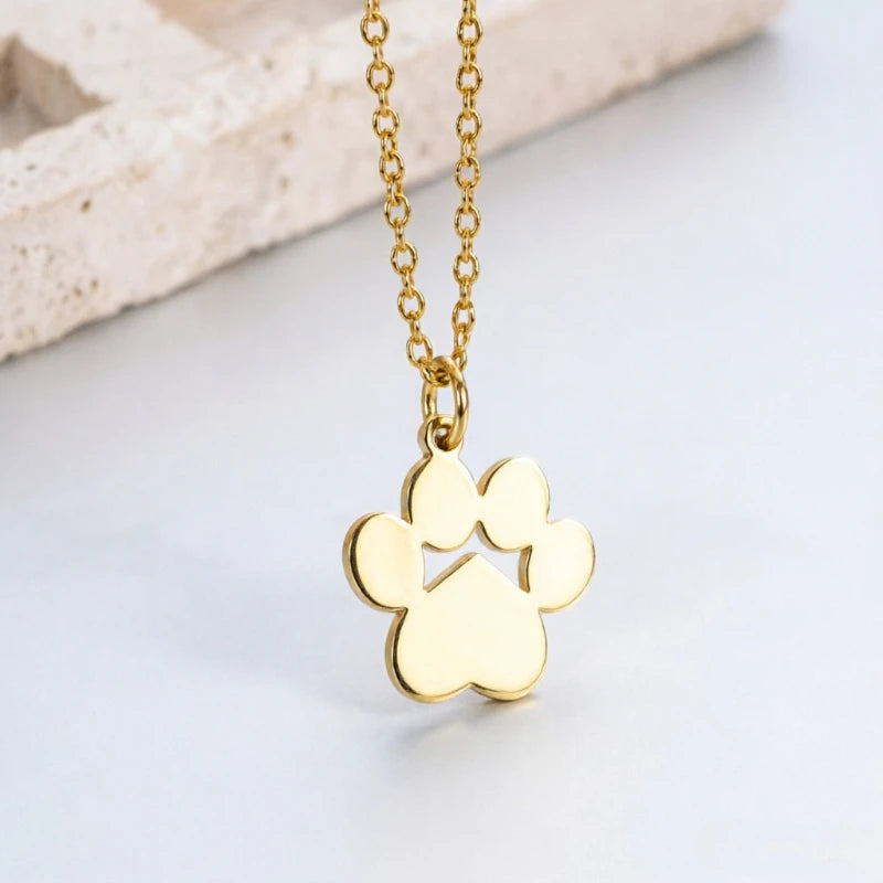 A gold-colored stainless steel cat paw pendant necklace displayed on a white surface.