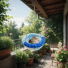 A bird hanging hammock made of blue and white fluffy material suspended outdoors.