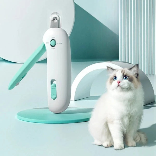 A white pet nail clipper tool is shown next to a fluffy white cat sitting on a light blue surface.