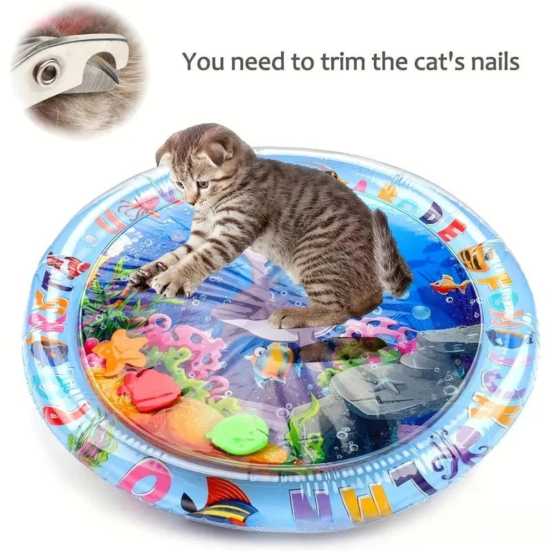 A kitten is playing on a blue mat designed with an ocean fish pattern, needing nail trimming.