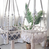 A bohemian macrame cat hammock bed for pet decor featuring white and gray macrame netting.