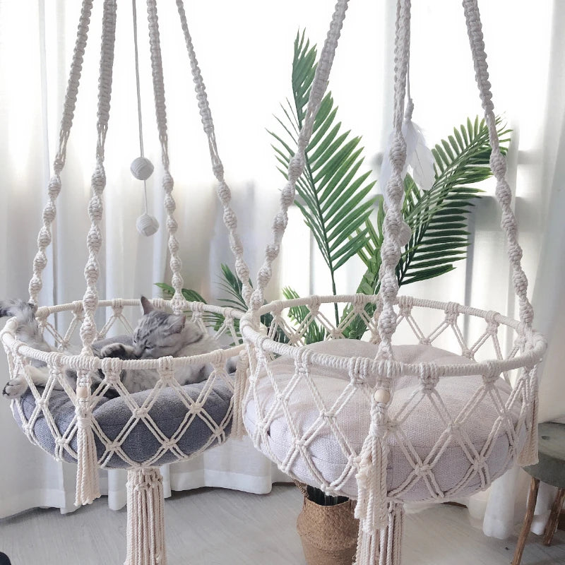 A bohemian macrame cat hammock bed for pet decor featuring white and gray macrame netting.