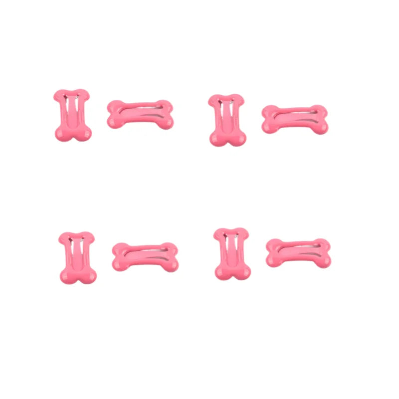 A set of pink bone-shaped hair clips used for pet grooming.