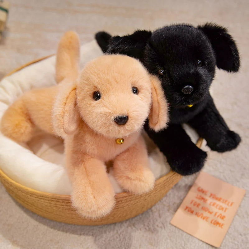 A fluffy golden retriever plush dog toy lying next to a small black puppy.