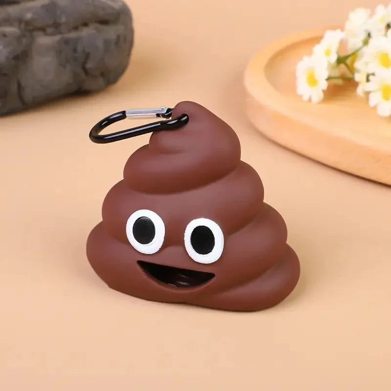 Dispensador de silicona marrón con forma de excremento de perro, ojos blancos grandes y boca sonriente.