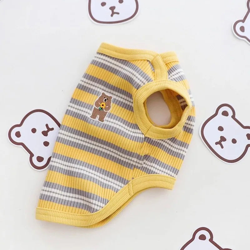 A yellow and gray striped stretchy pet tank top for cats and small dogs lying on a white surface.