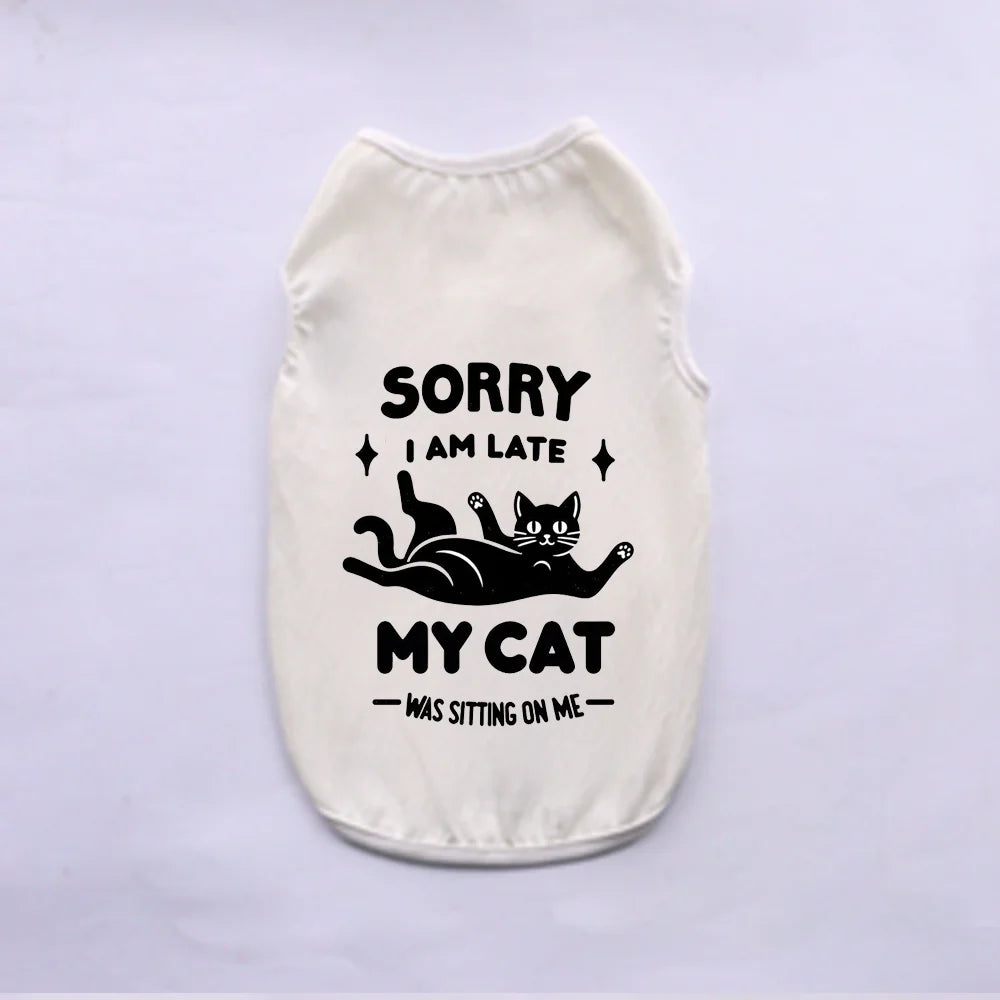 A cream-colored pet vest with black text that reads Sorry I am late my cat was sitting on me