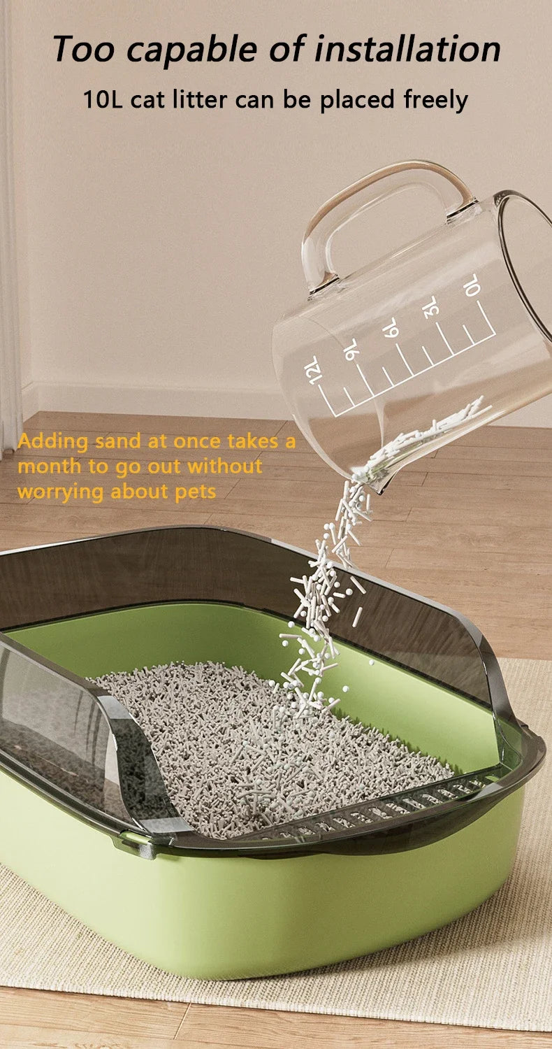 A clear plastic cat litter box is shown with sand being added, demonstrating its ease of installation.