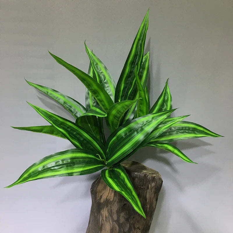 A vibrant green artificial tropical palm plant with variegated leaves displayed on a wooden base.