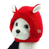 A red knitted ear muff for a dog, featuring white inner ears and a small brown tag.