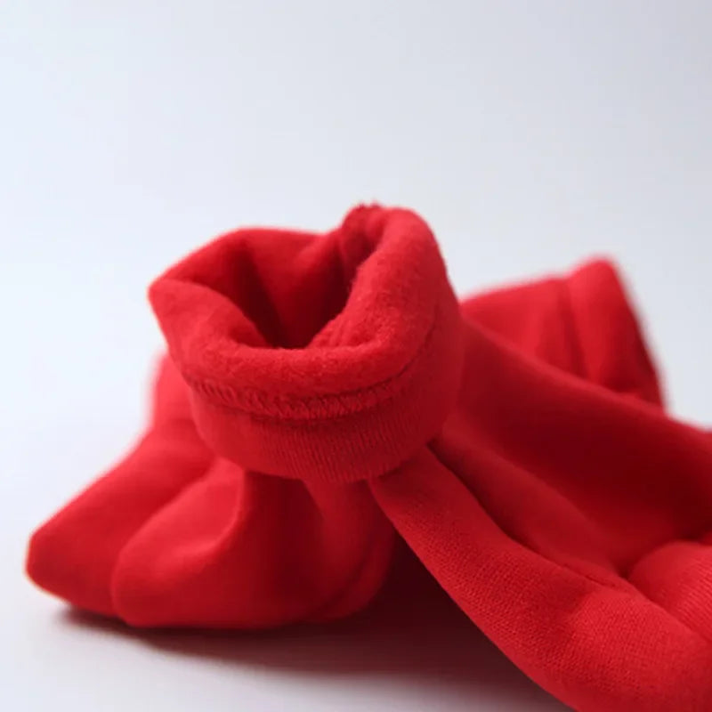 A bright red cozy fleece dog hoodie folded and displayed on a white surface.